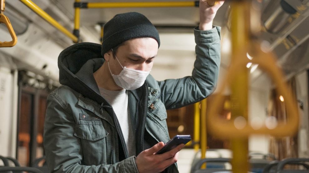 Man wearing face mask on a bus